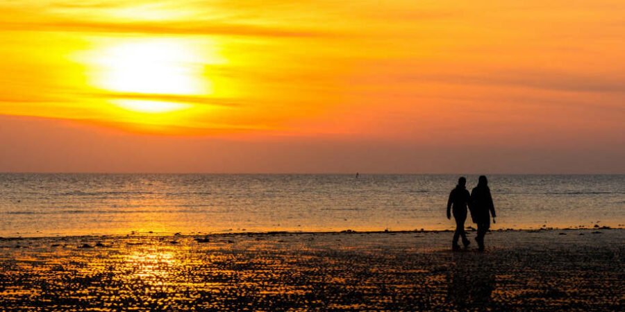 Des personnes sur une plage sur un coucher de soleil