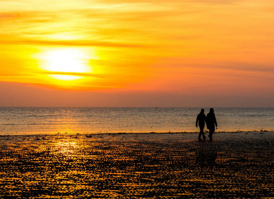 Des personnes sur une plage sur un coucher de soleil