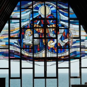Vitrail d'une église où nous voyons l'Eucharistie, l'Agneau immolé et la colombe de l'Esprit