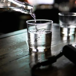 Une carafe verse de l'eau dans un verre